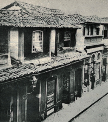 A street with buildings and a train track

Description automatically generated