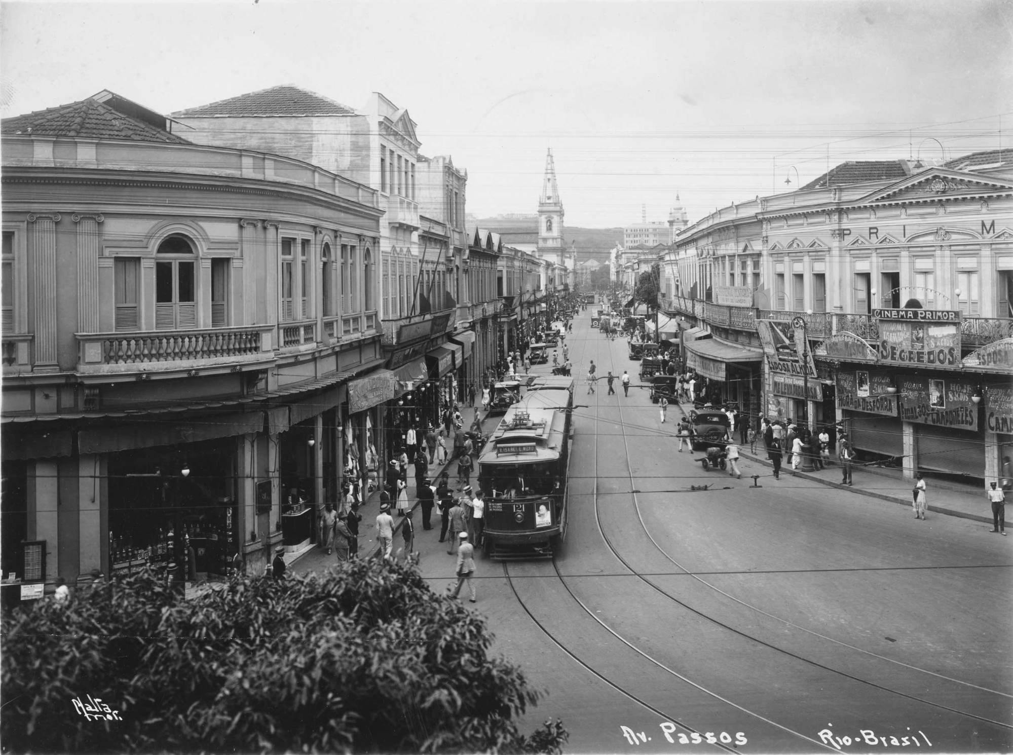 A street with a trolley and people walking on it

Description automatically generated
